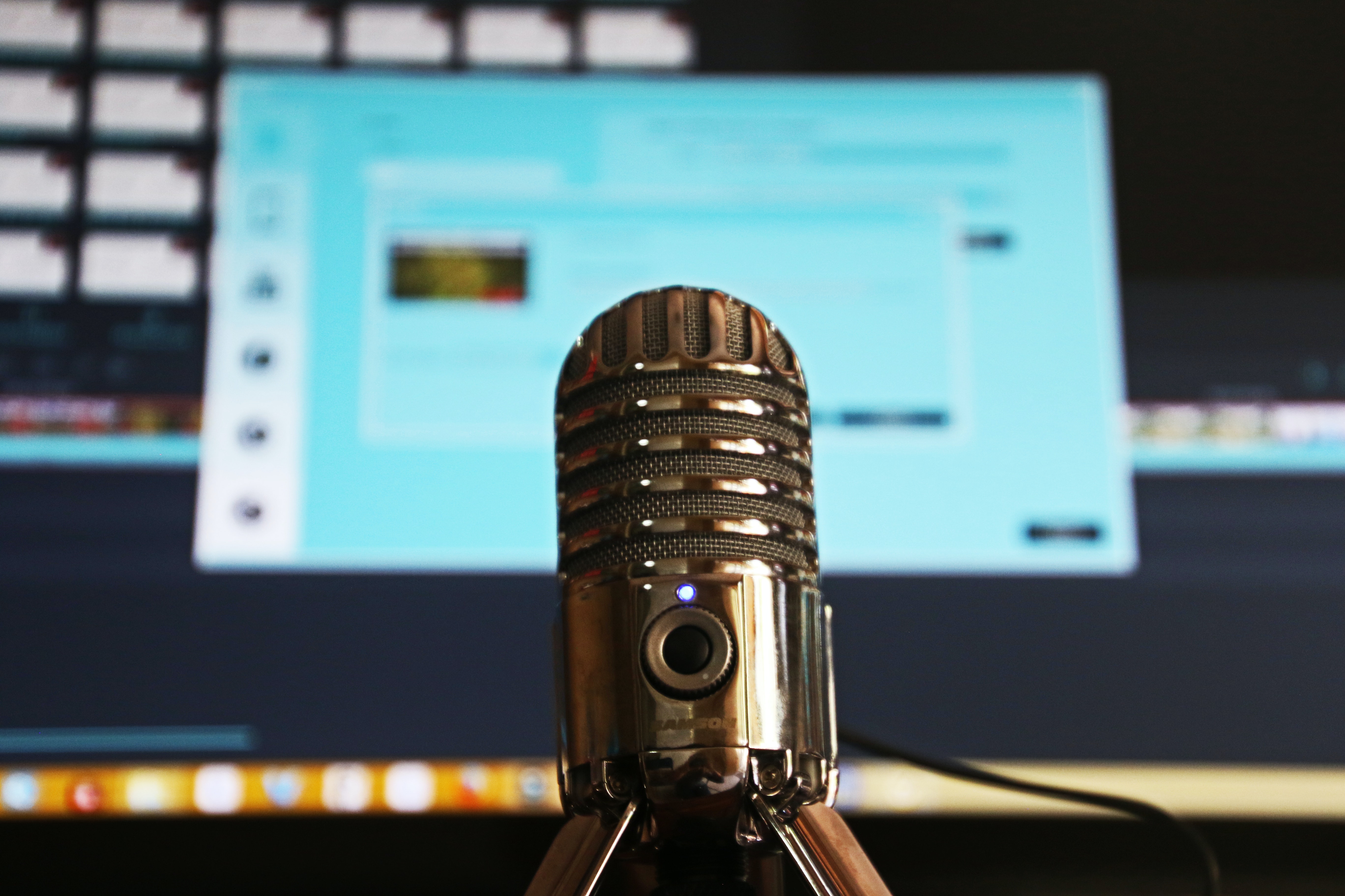 microfone e computador aberto em página de edição de um podcast 