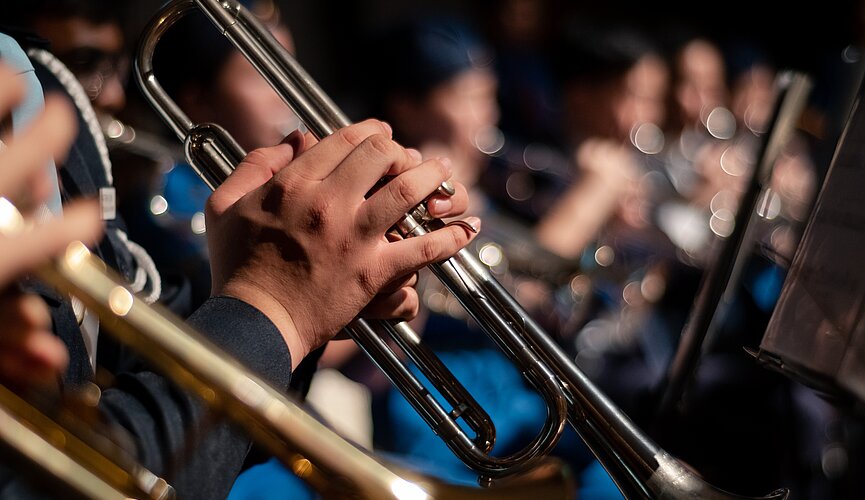 Na imagem é apresentado musicistas tocando trompete.