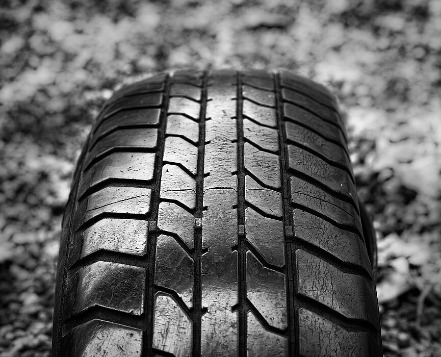 foto de um pneu contra um chão de pedregulhos - imagem em preto e branco