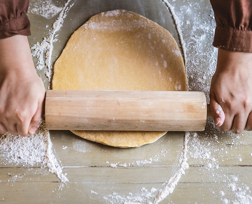 Chef abre massa com um rolo de cozinha