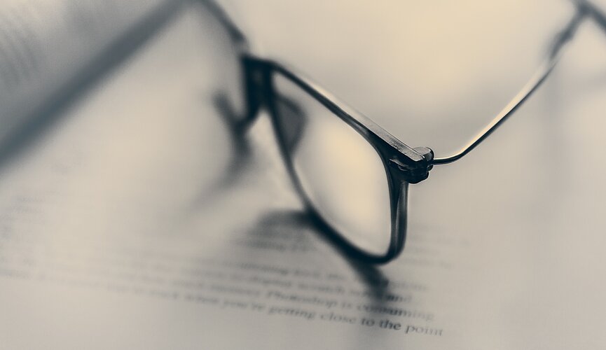 óculos sobre páginas de livro