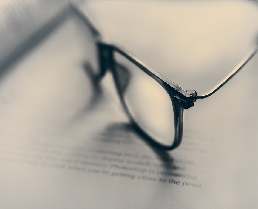 óculos sobre páginas de livro