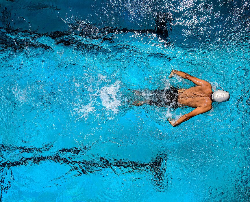 Imagem com um nadador dentro de uma piscina