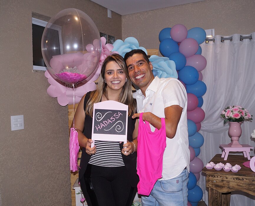 Daniel Dias e sua esposa Raquel Andrade segurando lousinha com o nome da filha