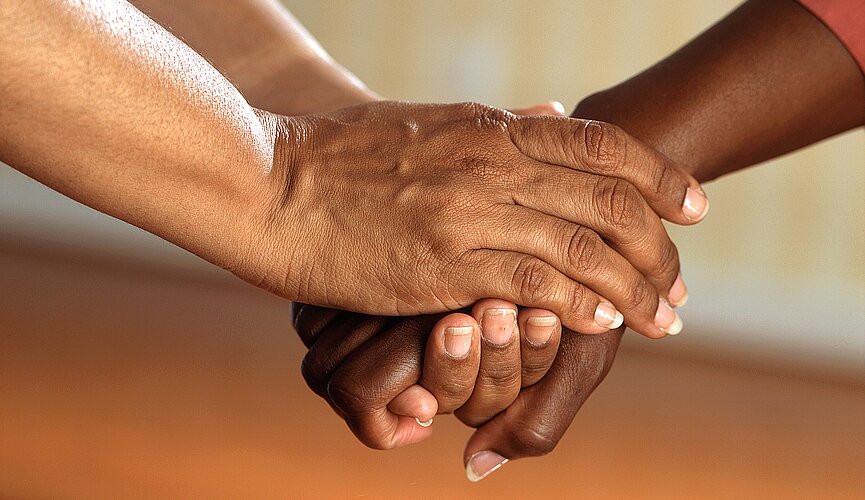 Imagem com três mãos uma em cima da outra