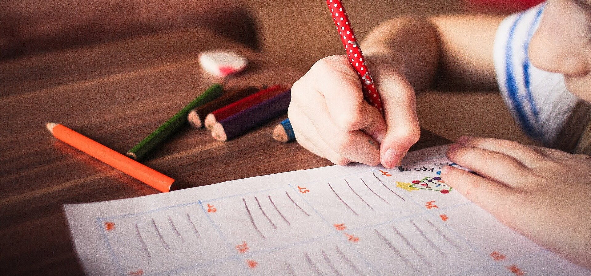 menina desenhando em papel com lápis coloridos