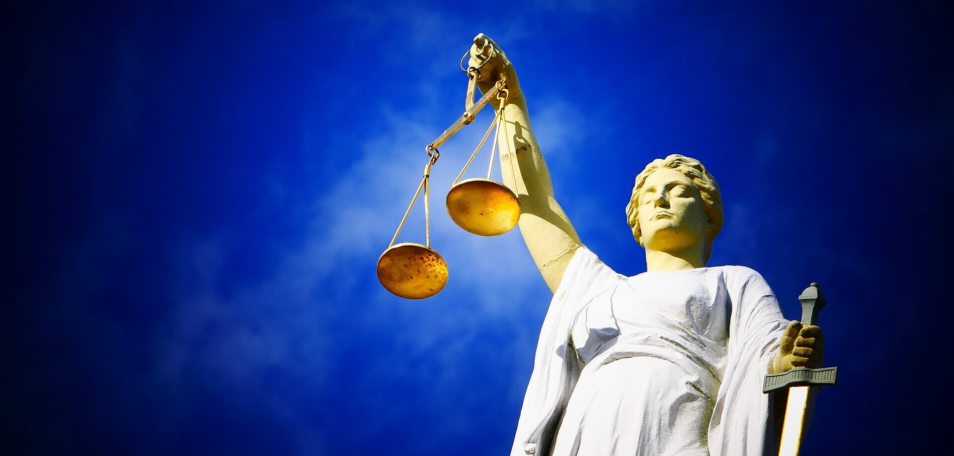 Imagem de uma estátua segurando uma balança, objeto símbolo do julgamento.