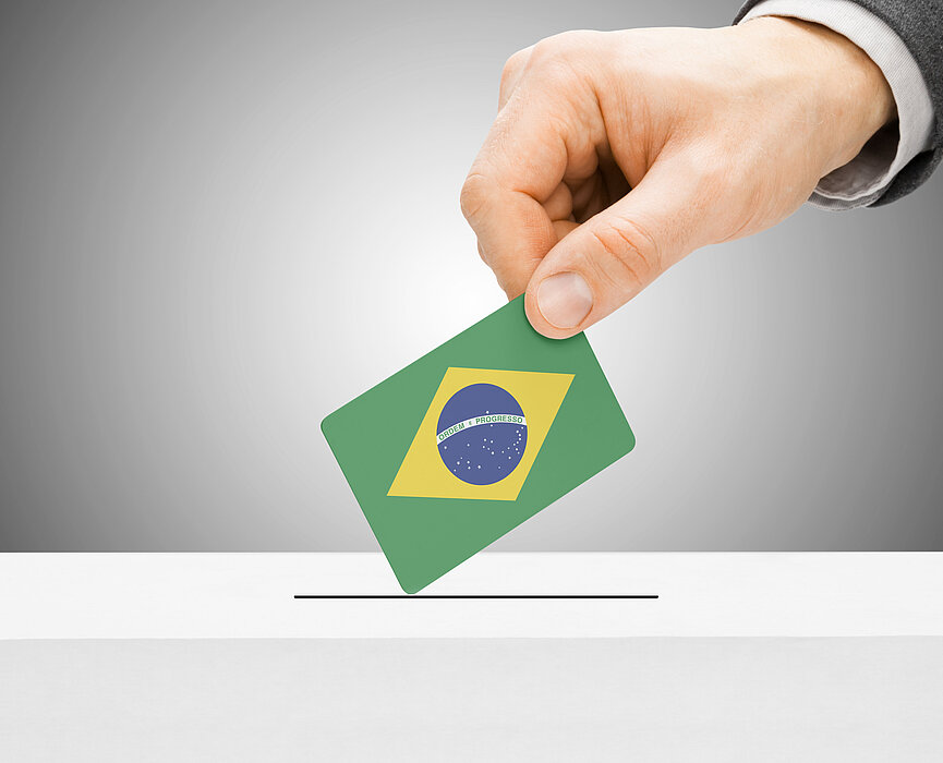 mão coloca voto com bandeira do Brasil em urna