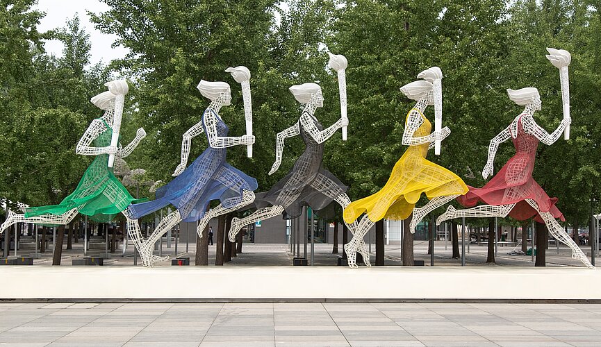 Estátuas de mulheres correndo com a tocha olímpica