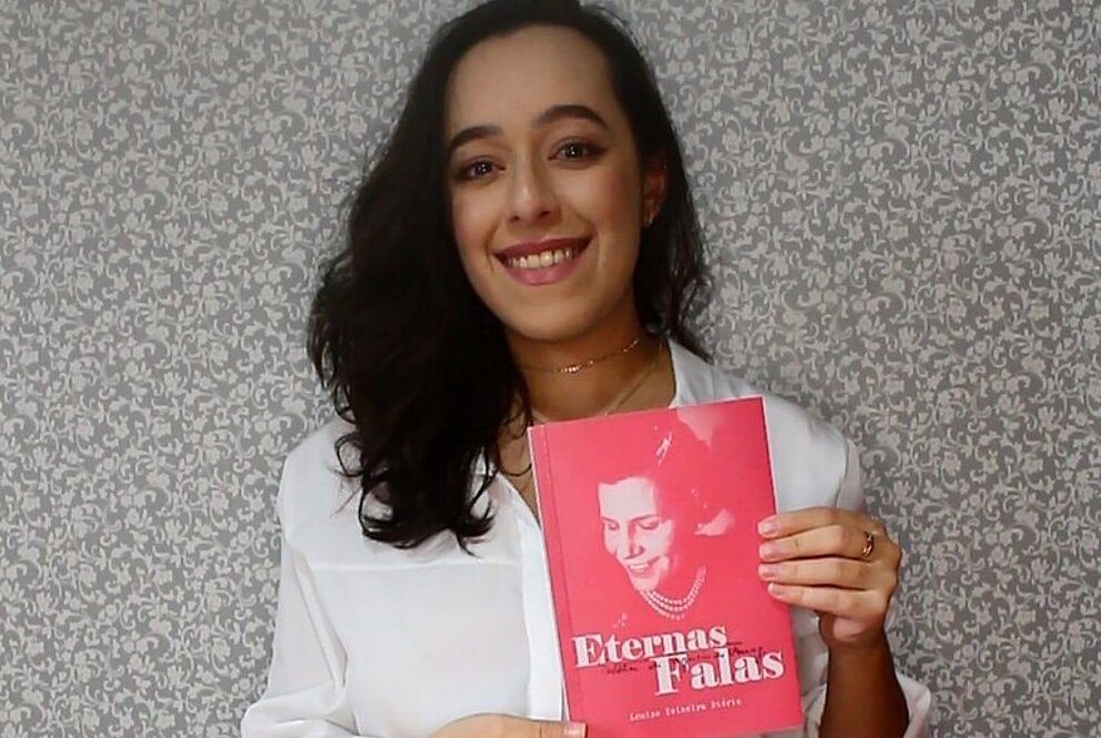 Autora Louise Teixeira Diório segurando seu livro